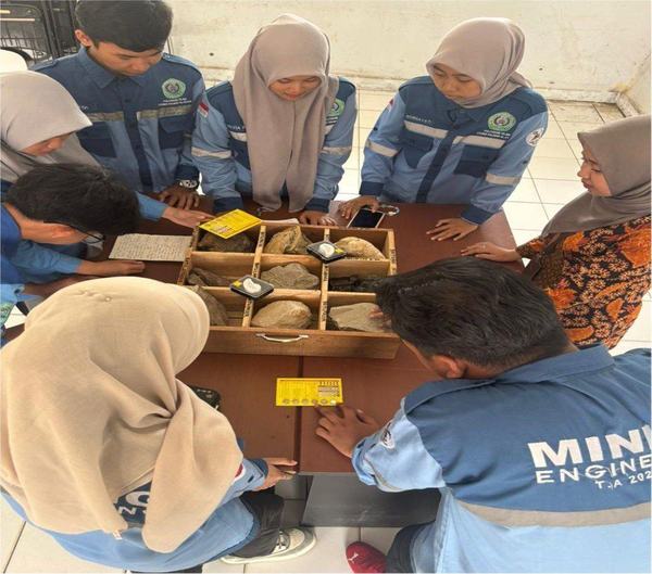 Mahasiswa mengelilingi kotak spesimen batuan di atas meja