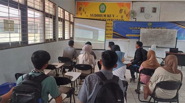 Mahasiswa menghadap layar proyektor dalam sesi kuliah hybrid